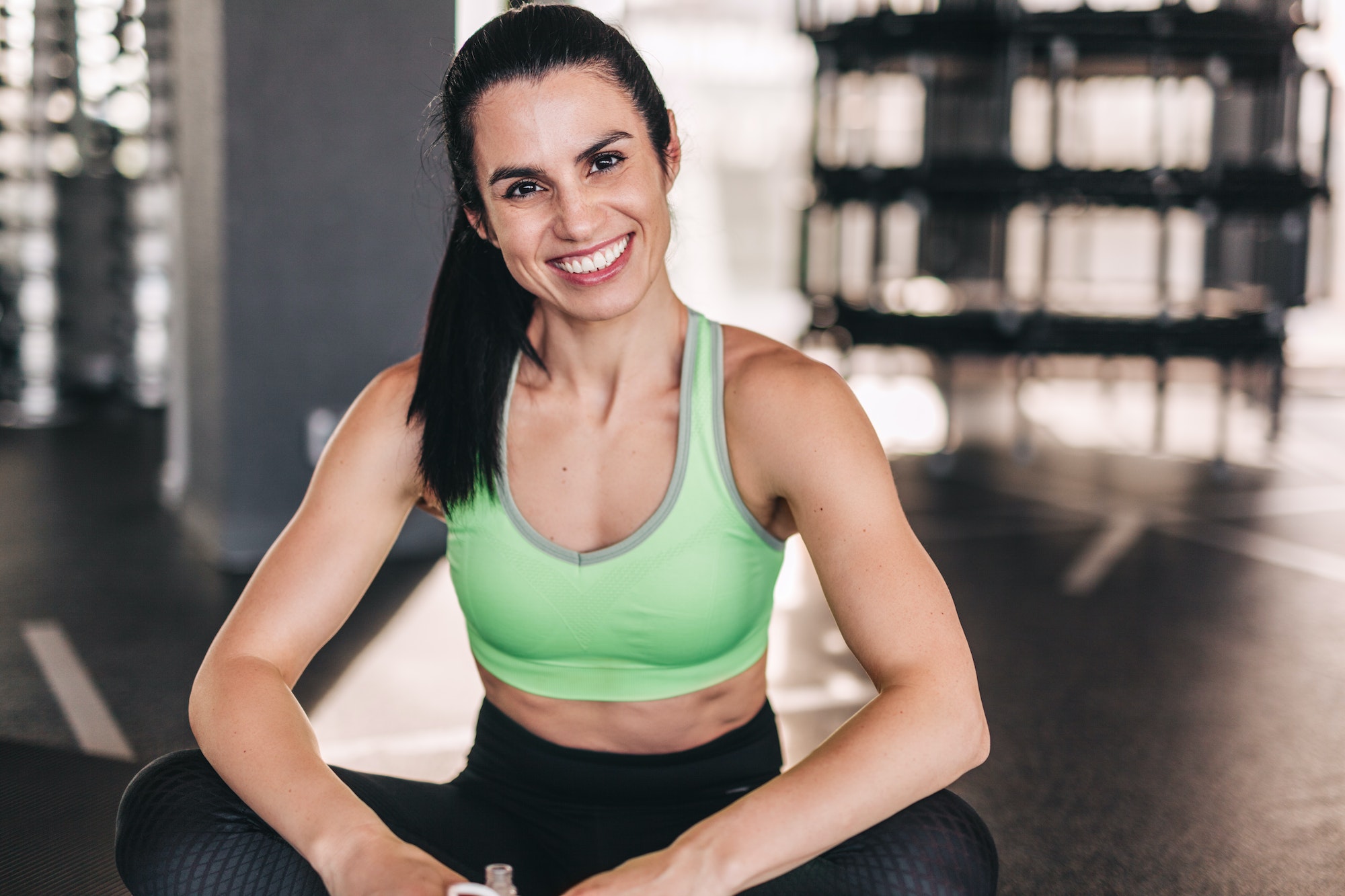 Cheerful woman sitting in gym